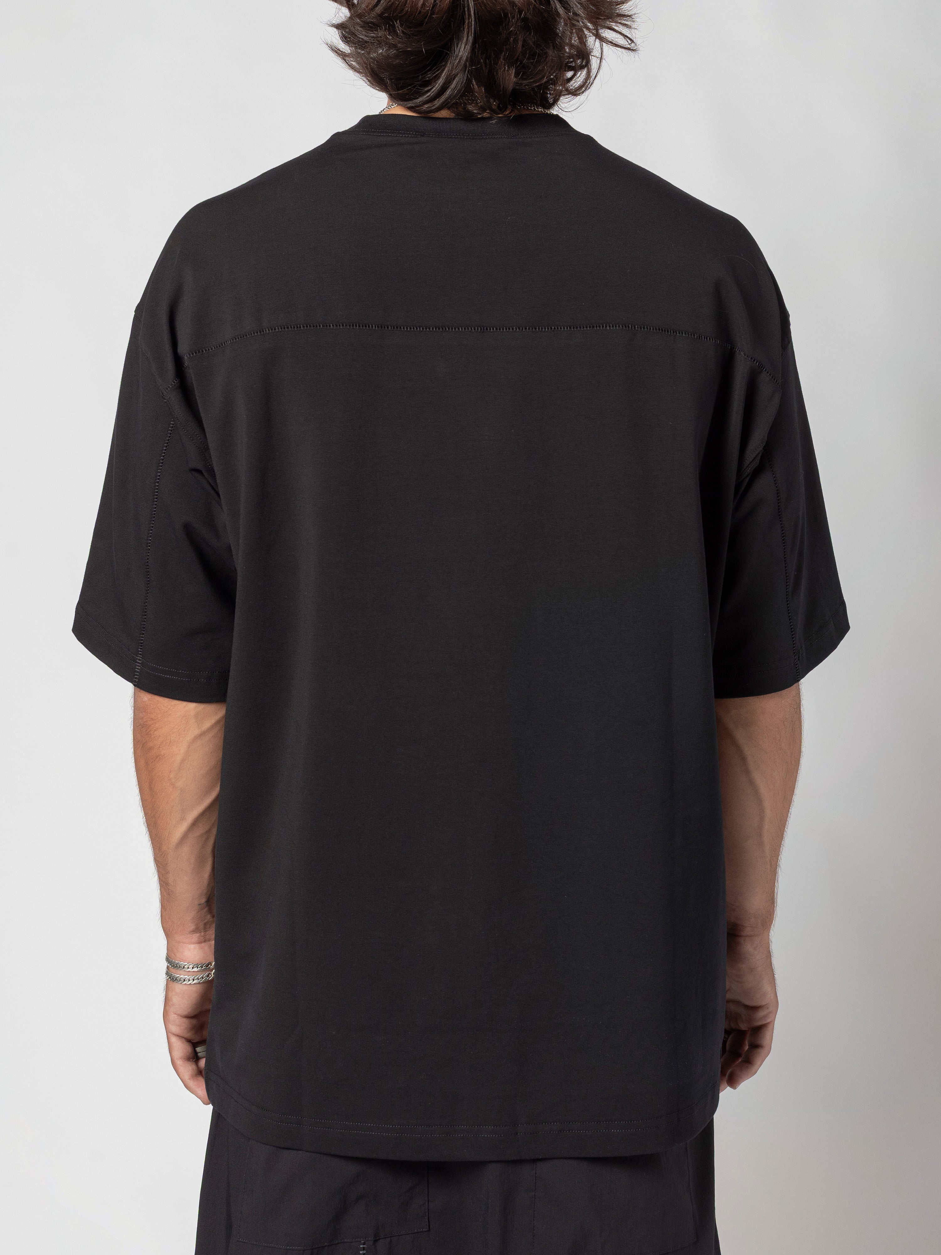 AITO Oversized Cotton T-Shirt in Black - back view of the torso, the seam running straight across the upper back, arms hanging at the sides