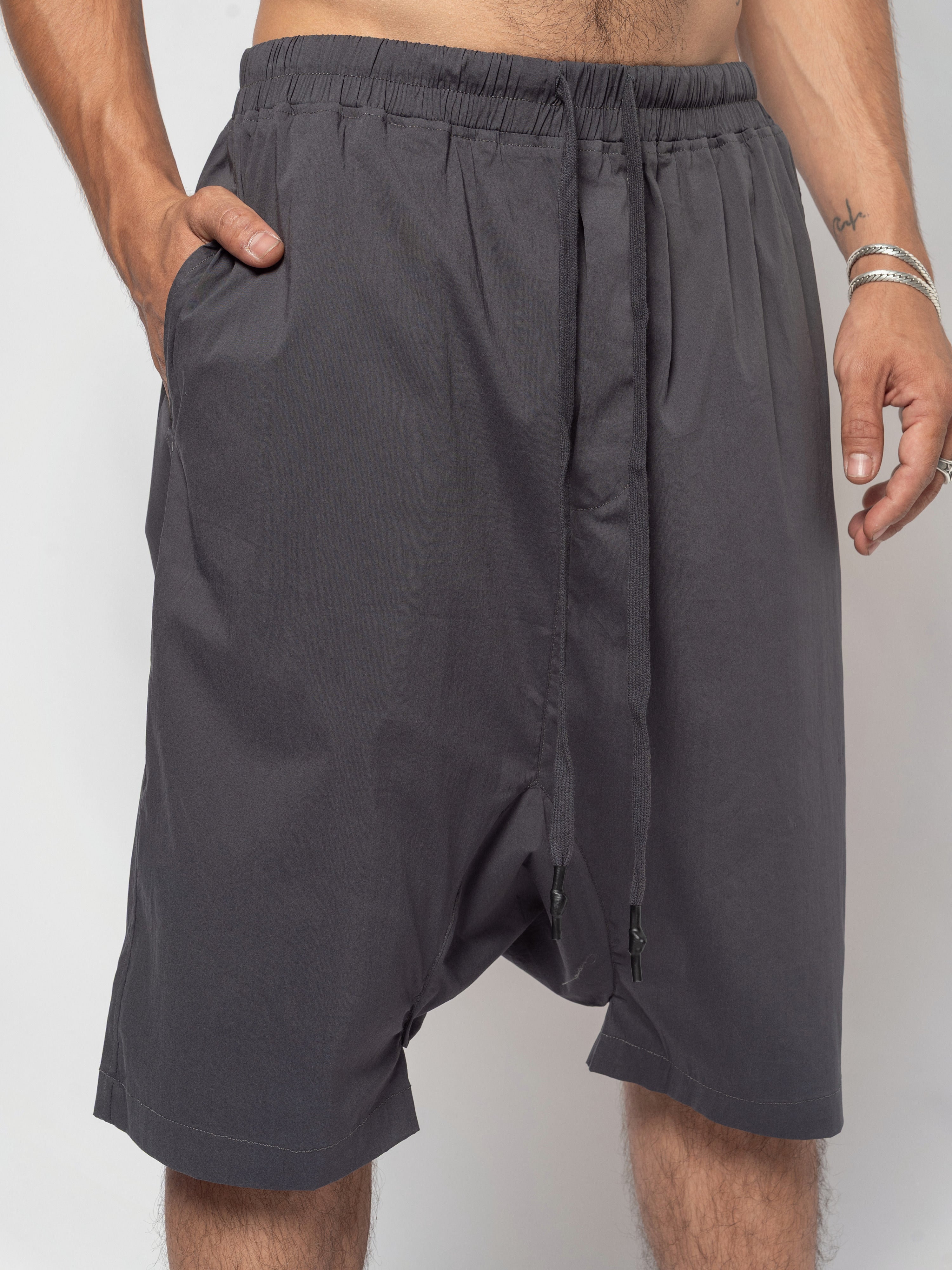 AITO Drop-Crotch Cotton Shorts in Dark Grey - front view from waistband to mid-thigh, one hand tucked into the side pocket