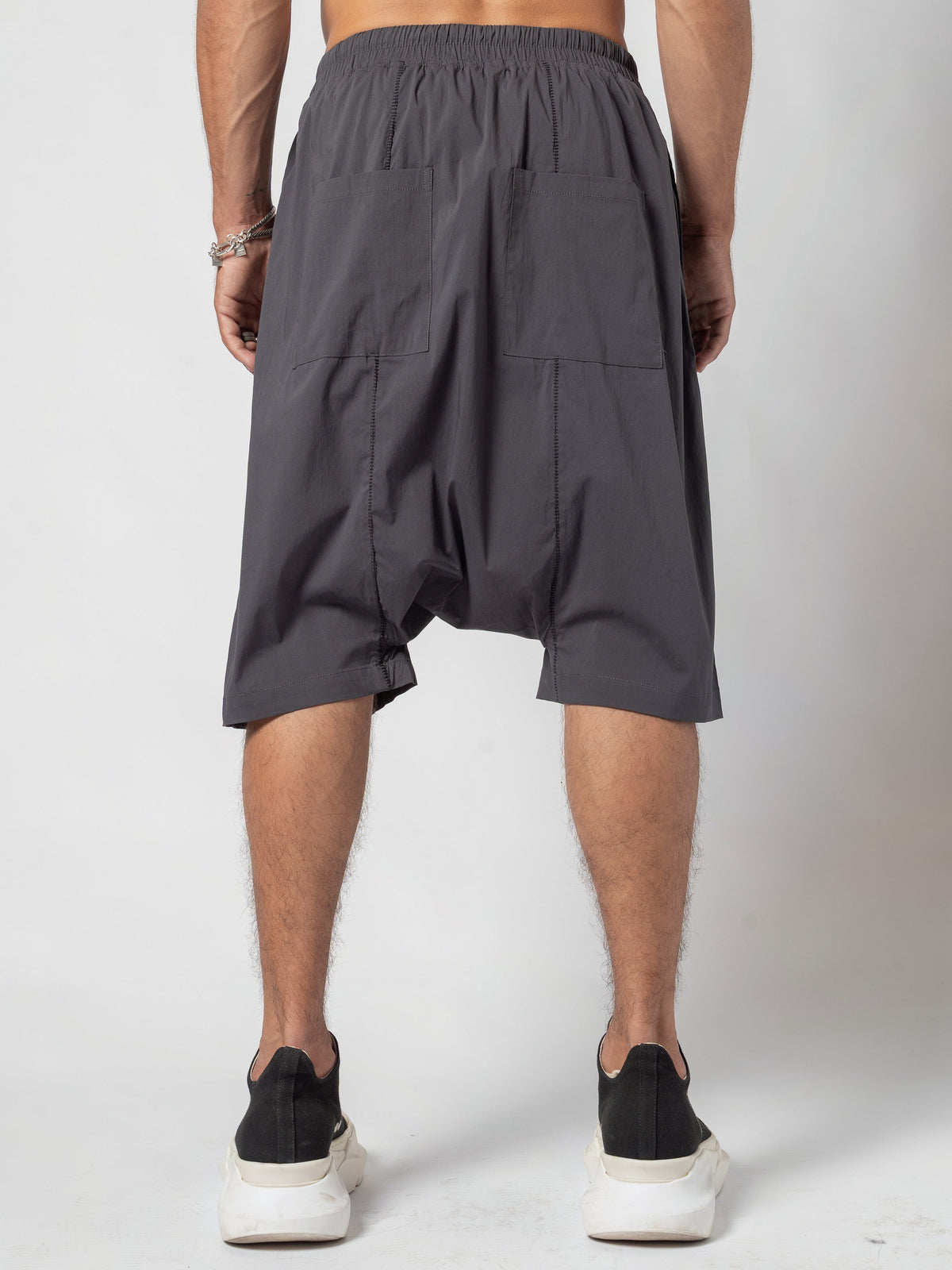 AITO Drop-Crotch Cotton Shorts in Dark Grey - back view from the waistband down, both hands at his sides and both feet flat