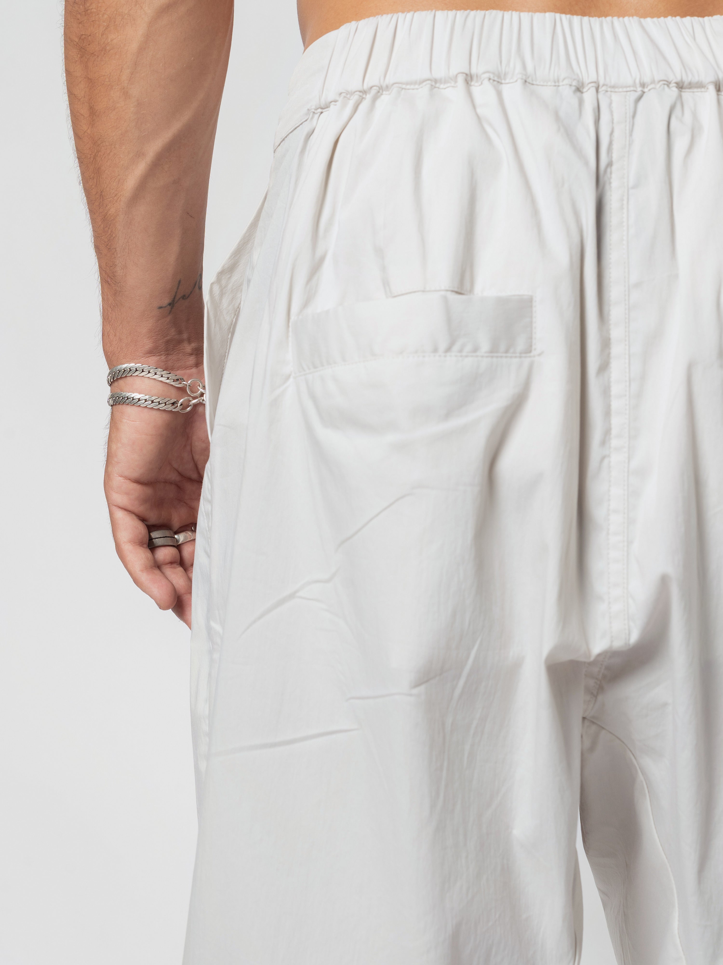 AITO Pleated Drop-Crotch Pants in Off White - close-up of one back patch pocket and the gathered elasticated waistband