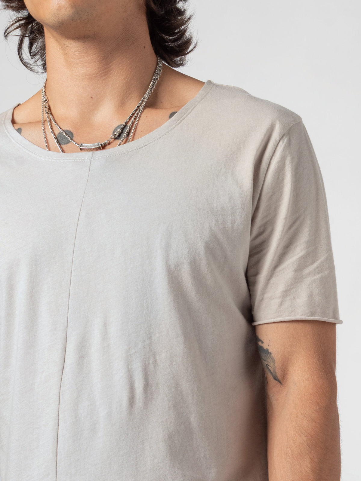 AITO Scoop Neck Cotton T-Shirt in Off White - close-up of the chest, neckline and centre-front seam with the sleeve opening at the edge of the frame