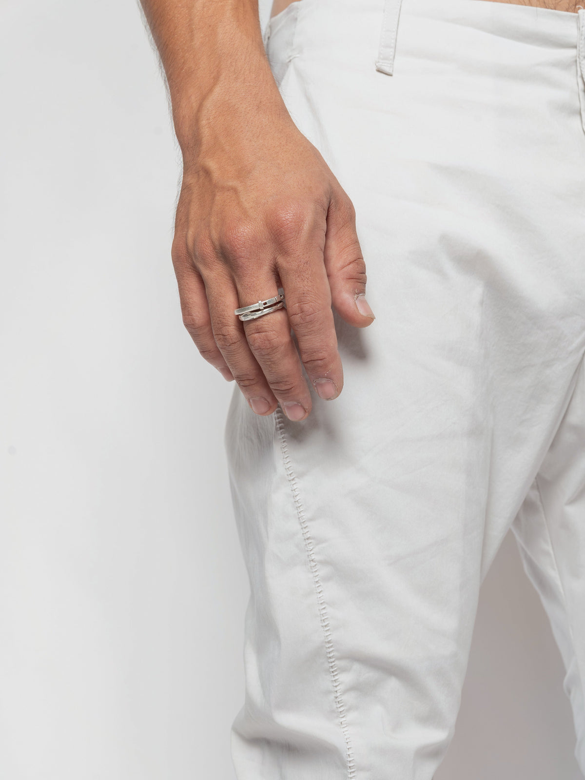 AITO Stacked Hem Slim Pants in Off White - side of the hip and upper thigh, the outseam running down past a hand held loose at the side