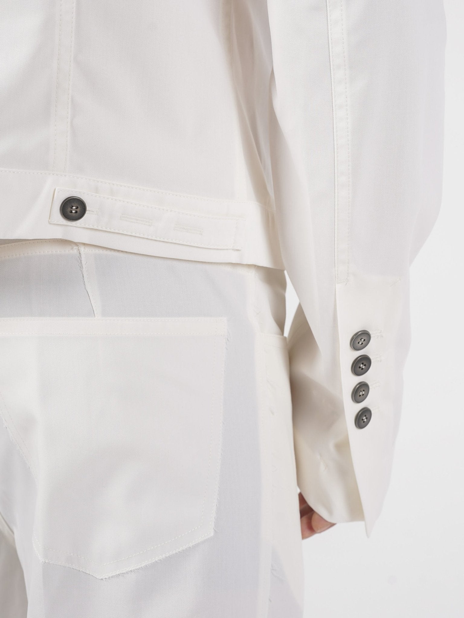 SAPIO cropped jacket cuff and hem tab detail - four-button extended cuff, adjustable tab